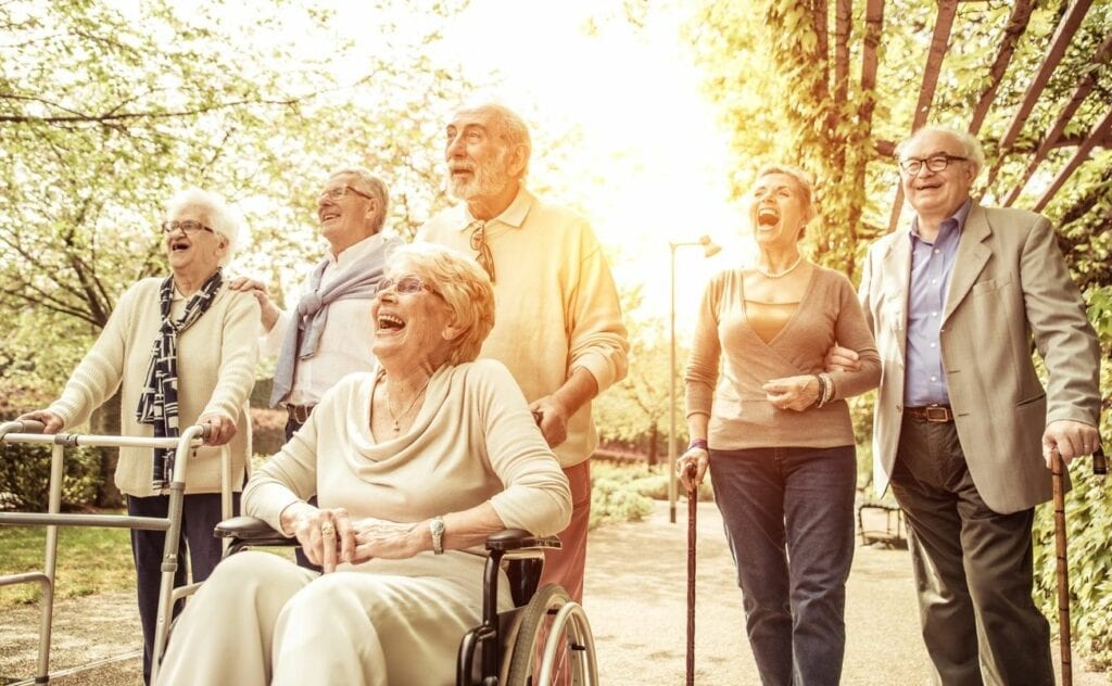 Group of seniors walking and laughing outdoors